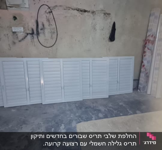 תריסים לבנים מונחים על רצפת בטון בחדר עבודה